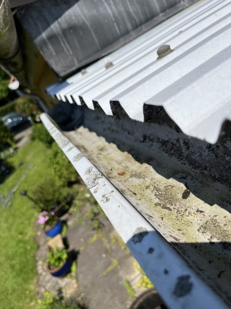 Snavset tagrende på hus med metaltag før rensning